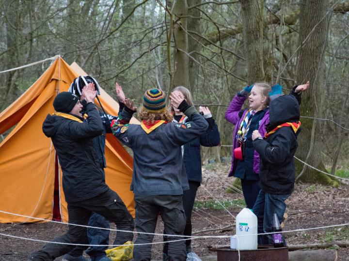 Spejderpatrulje der er ved at high-five 